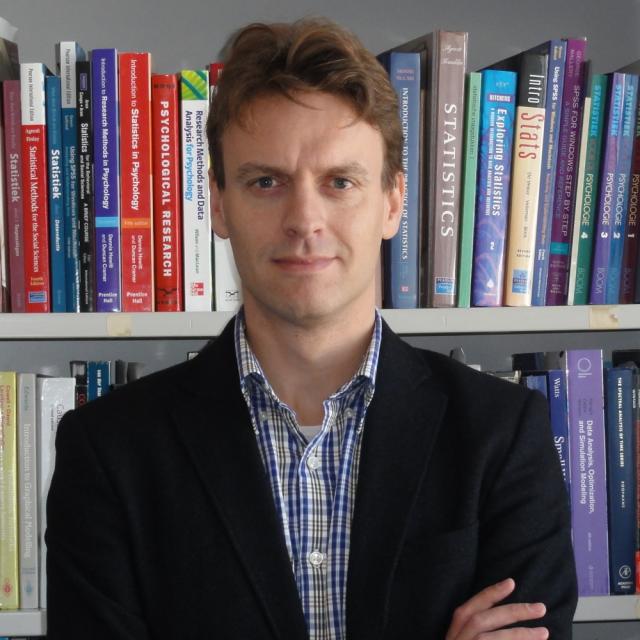 Headshot of Eric-Jan Wagenmakers in front of books